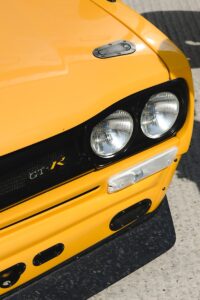 A bright yellow classic nissan gt-r.